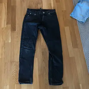 Ett par svarta jeans från Weekday i storlek 28/30. Modellen är Pine Regular Tapered Jeans.