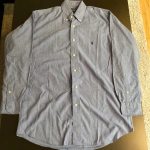 Ralph Lauren skjorta - Riktigt fin Ralph Lauren skjorta. Färgen är blå men lite mer till det mörk blåa. Perfekt till sommaren och storlek M (passar även L).
