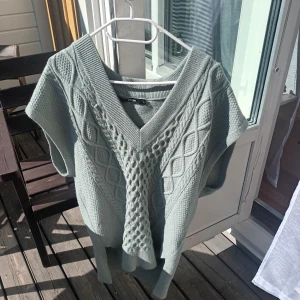 sage green stickad väst - en fin stickad väst som är matcha/sage grön med mönster där framme. Står storlek S men kan passa upp till L/XL