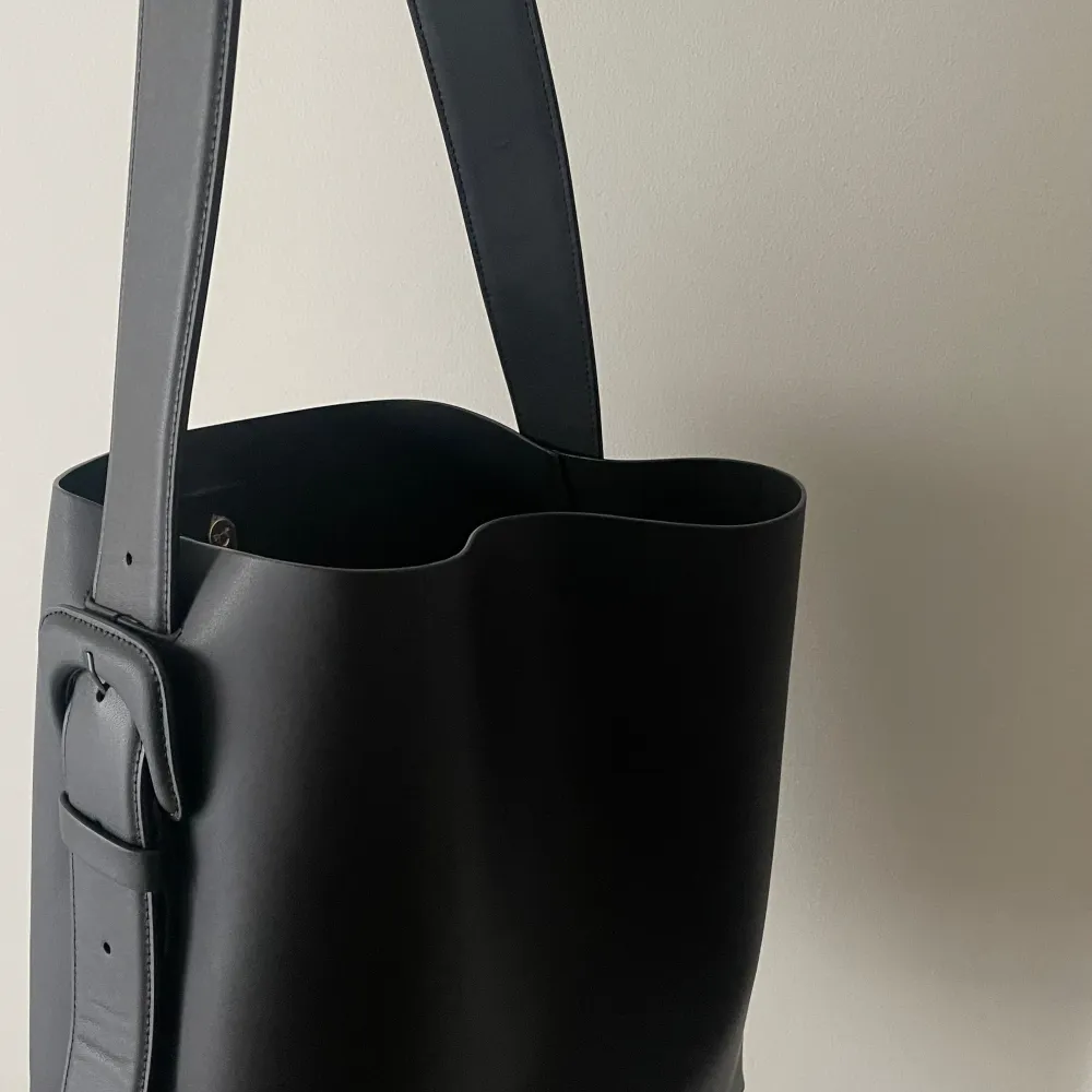 Tote i läder med plats för en bärbar dator. Den har en justerbar axelrem som är 5 centimeter bred och magnetisk stängning. Innerfack med dragkedja. Mått 35 × 32 × 13 cm. Får plats med en bärbar dator! Nypris 3300:- Pris går att diskutera. Dock är den helt ny och oanvänd. . Laukut & Käsilaukut.
