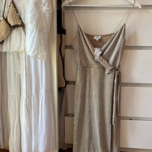 Guld klänning - Oanvänd klänning med prislapp. En söm har spräckts långt ner på klänning och den var så när jag köpte den. Kan enkelt fixas❤️