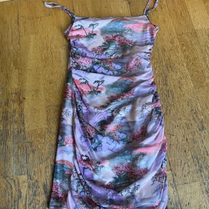 Tight klänning med asiatiskt tema  - Otroligt skön och stretchiga- dubbel fodrad på grund av det genomskinliga materialet, använd fåtal gånger    Perfekt för fest - kan stylas med klackar och stora örhängen - eller till vardag - med sneakers och en jeansjacka 