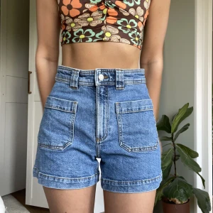 & Other Stories jeansshorts - Högmidjade jeansshorts med fickor framtill. Tyget har lite stretch och sitter därför så smickrande över rumpan. Inköpta på & Other Stories, jättefint skick. 