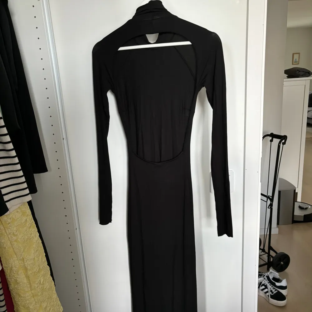 En lång lite tunnare svart klänning från Gina Tricot 🥰 storlek XS! Supersnygg öppen rygg med hål för tummarna i slutet på ärmarna 🩷 . Klänningar.