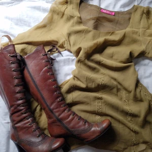 Klänning + boots - Olivgrön "flowig" klänning i tunt material och ett par höga rödbruna boots. 