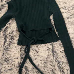 Tröja  - Väldigt söt tröja som man kan knyta där bak på ryggen, tröjan har även en väldigt fin färg.