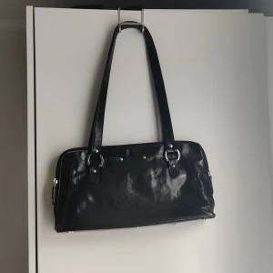 The Monte väska  - Säljer den här väskan från The Monte. Den är svart med silvriga detaljer.