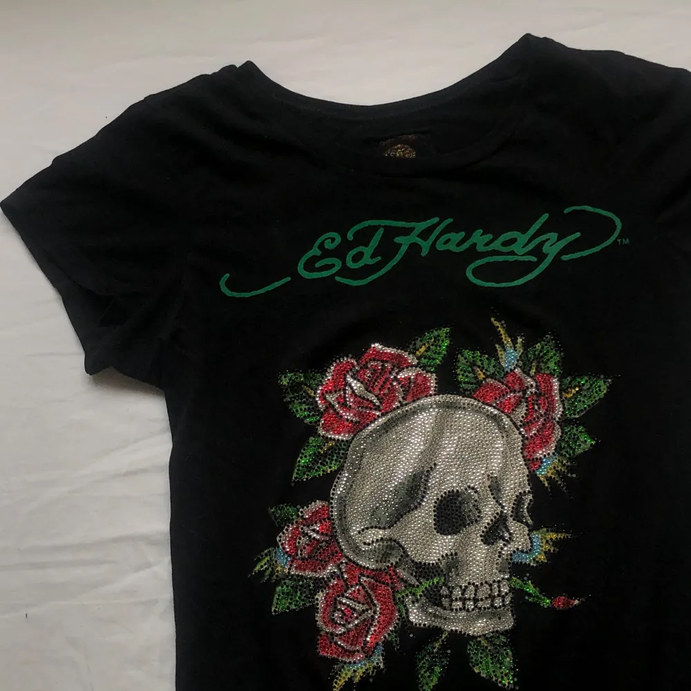 Jätte cool t-shirt från Ed Hardy. Den är lång så funkar att ha som både en kort ”klänning” eller en topp om man viker upp den tex. Några diamanter har lossnat men absolut inget man tänker på, annars jätte fint skick. Skick vid frågor💕. T-paidat.