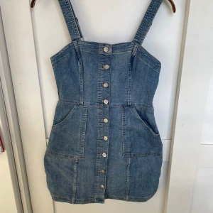Jeans klänning  - Jeans klänning med knappar upp. Tygen är stretchigt och ska sitta som typ bodycon. Har fickor fram. Är knappt använd.  Frakt ingår inte i priset.