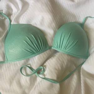 Shiny blue bikini överdel🩵✨ - Fin ljus blå blandat med turkos bikini överdel med glitter🩵. Den har en defekt på kanten som jag inte vet hur den har fått ska se om det går bort. säljer pga för stor för mig🩵! Köpte bara överdel. pris kan diskuters, Skriv om ni vill ha fler bilder🩵!