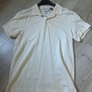 Pikétröja från HM  - Vi har precis fått in en somrig och fin pikétröja från H&M i färgen beige perfekt till sommarhettan. Nypris:249kr Cond9/10 med tag finns kvar använd 1 gång