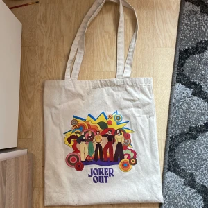 Joker out totebag  - Säljer denna joker out totebag då jag inte lyssnar på deras musik längre.  Köpt för 15€ på deras hemsida vilket blir ca 174kr men säljer den för 150kr💕😊 Den är lite smutsig längst ner men går säkert att tvätta🙃 