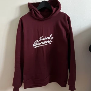 Saint Laurent Hoodie - Årets fetaste Hoodie har anlänt. Tröjan är köpt på en secondhand för några månader sedan men kommer aldrig till användning. Det låga priset kommer från ett fabriksfel som innefattar att en söm inte är helt i sin ordning. Inget som syns egentligen 