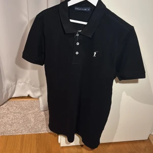 Svart polo piké  - En svart piké i storlek M, den är slim fit, helt oanvänd och är i perfekt skick. Pris kan diskuteras 