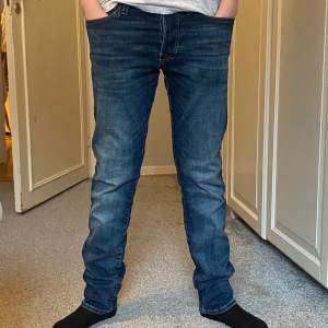 Mörkblåa jeans från Jack and Jones som är storlek 27/30 