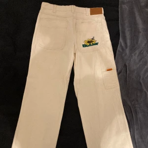Butter chinos från junkyard  - W28 loose fit tryck på bakfickan samt en del detaljer, skriv gärna innan köpet eller om frågor behövs besvaras. Defekter: snörerna inuti byxorna finns ej med, bälte kan då behövas 
