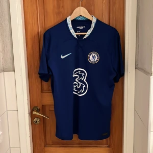 Chelsea 22/23 hemmatröja  - Tja! Säljer mitt Chelsea kit som ja köpte i london. Den är i mycket fint skick och enda anledningen ja säljer är för ja inte är Chelsea supporter. Storlek L