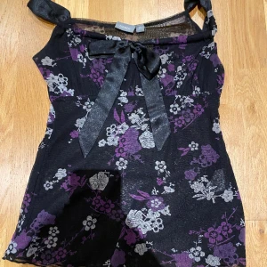 Topp - Härlig och fin topp från Lindex. Blommig och med en fin rosett längst fram. Säljer pga stor garderobrensning. Kika gärna på mina andra annonser, säljer mycket. Samfraktar gärna:) 