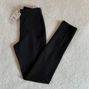 ZARA svarta kostymbyxor / stretch - Byxor med stretch / kostymbyxor från ZARA med otroligt smickrande passform. I nyskick, med tags och utan anmärkningar. Nypris 359kr. Dragkedja vid anklarna som går att öppna ifall man vill ha slits / lösare passform.