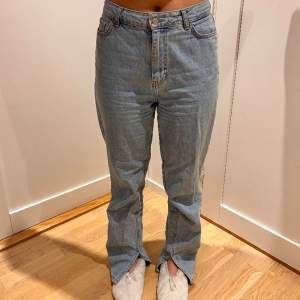 Ljusa jeans från NA-KD med slits vid anklarna. Kan upplevas lite stor i storleken beroende på kroppstyp. Tjejen på bilden är 165 cm lång.