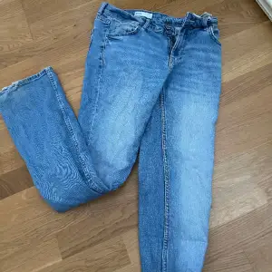 Blåa utsvängda jeans frpn bershka. Lite slitningar längs nere men inget som är trasigt. Rätt små i strl