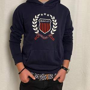 Jag säljer en Gant hoodie i färgen blå samt vit med röd logga. Den har använts ett par gånger men använts sparsamt | Skick 7,5/10 nypris ca: 900 kr | mitt pris 299 kr. Hör av er vid intresse eller funderingar!