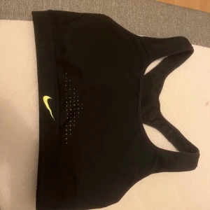 Nike,Sport topp/Sport bh - Mycket stödjande sport bh från nike. På visss går det att ta ut paddingen men här går det ej. Inget syns genom det heller.