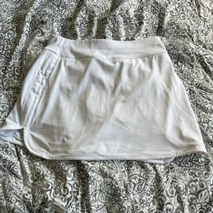 vit kort kjol - säljer den här jätte fina korta kjolen med shorts inuti som inte kommer till användning, står inte storlek men skulle säga att det passar XS och S❤️ jätte skönt material❤️