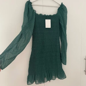 Mörkgrön klänning - ALDIG ANVÄND, LAPP KVAR. Supersöt tajt klänning från Asos med söta detaljer. Är storlek 40 men skulle säga liten i storleken, passar bättre till 38💚