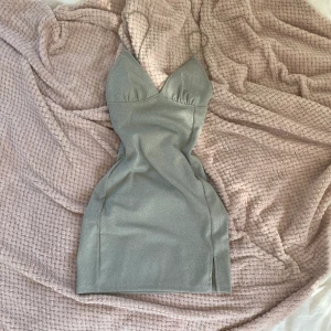 Silvrig klänning - Snygg silvrig klänning med öppen rygg! Köpt rea därav priset, aldrig använd endast testad, lappen kvar. Skriv gärna i DM vid frågor 💗