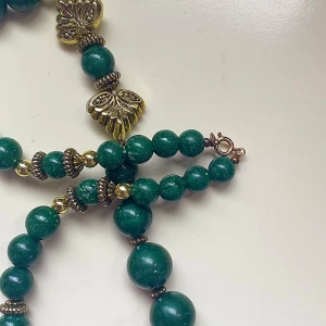 Vintage halsband  - Vintage halsband med gröna pärlor och guldfärgade detaljer i plast  Ca 58 cm långt 