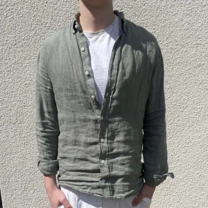 Linneskjorta  - Säljer denna feta linneskjortan i färgen khaki. Skjortan är perfekt nu till sommaren och i utmärkt skick. Pris kan diskuteras vid snabb affär.