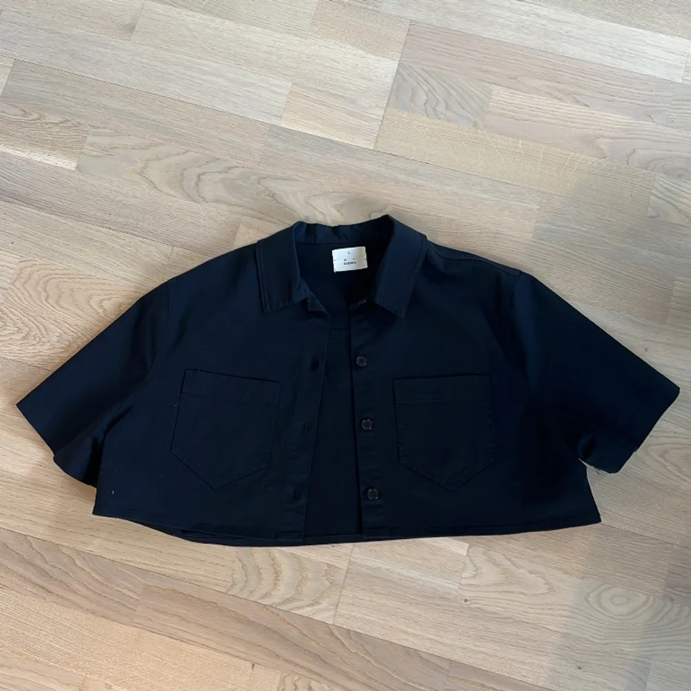 Säljer en svart kort skjorta från A-DSGN storlek L. Aldrig använd, 200kr. . Skjortor.