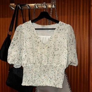 Blommig blus med markerad midja! - En ljus geön blus med vita små blommor med elastisk midja som ger en snygg figur! 💚🌸Den är från Only i storlek XS, använd endast ett fåtal gånger! 