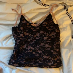 Rosa linne - Ett rosa linne med svart spets, har själv sytt in det och skulle säga att det passar en xs 