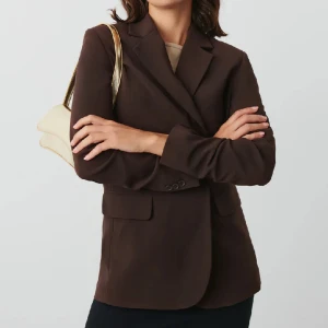 Brun kavaj  - Jättefin brun kavaj från Gina Tricot, använd vid två tillfällen så den är i jättefint skick. Materialet är tjockt och fint, bra kvalitet. Upplever den något liten i storleken, den är storlek 38 men mer som 36. Säljer även byxorna till. Ord pris 599kr