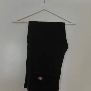 Ett par svarta byxor från Dickies i slim fit, storlek 28/30. Tappat lite färg.