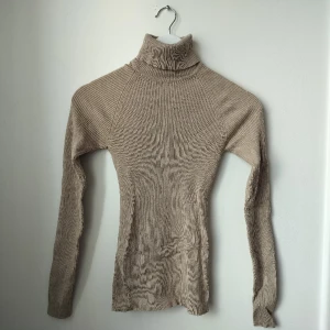 Rejäl beige polotröja storlek S - Beige polotröja i stadigt, tjockare material. Storlek S. Minihål i ena armhålan för den som kan sy ihop det själv (jag kan annars göra det), annars superfint skick!