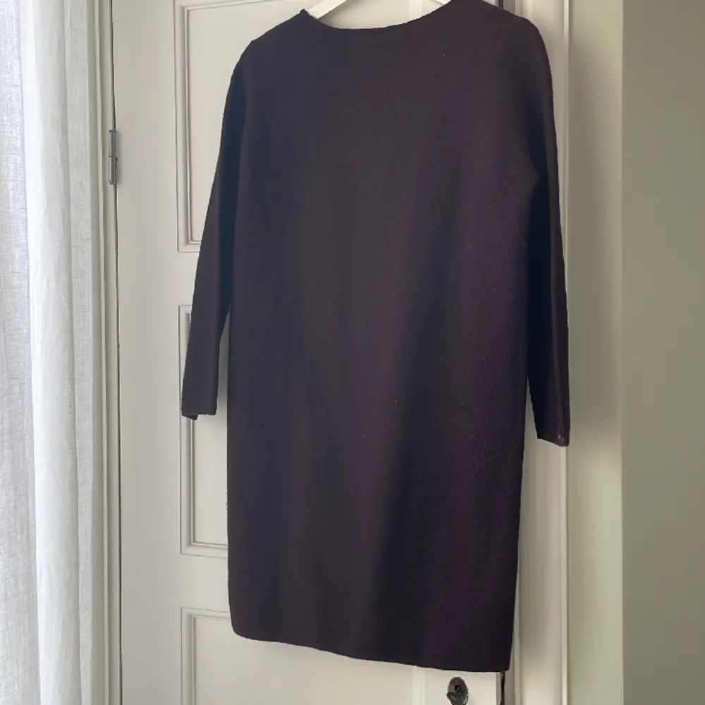 Knälång klänning från COS. 3/4 ärm. 100% ull. Oanvänd. Rak modell. Färgen är burgundy . Klänningar.