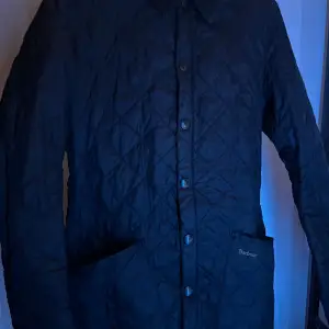 För en sofistikerad och formell look. Denna navyblå jacka från Barbour ger en touch av elegans till dun outfit, passar för både skola och en ute kväll. För endast 449kr är denna jackan din!