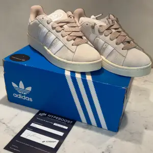 Adidas campus i färgen wonder white storlek 39 1/3. Helt oanvända. Vita snören ingår. Äktenskaps bevisade. 