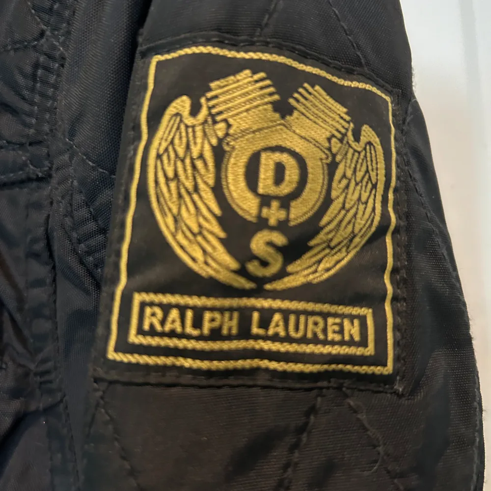 Aldrig använd så snygg Ralph Lauren vaxad jacka. Bara att inse den inte kommer passa en kurvig kropp. Storlek M. Mörkblå med amerikanska flaggan på ena ärmen. . Jackor.