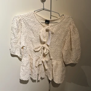 Gina Tricot Blus - Beige blus från Gina Tricot. Oanvänt med lapp. Storlek S