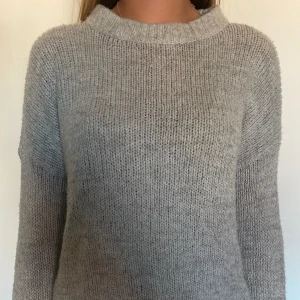 Grå stickad  - En grå lite tjockare stickad långärmad. Använd många gånger men fortfarande i bra skick.