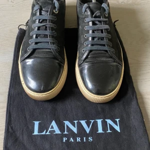 Lanvins - Lanvins i färgen svart vit, väldigt bra skick, kommer med dustbag bara. Storlek 42,5 men passar lite större. Priset går att diskuteras vid snabb affäf