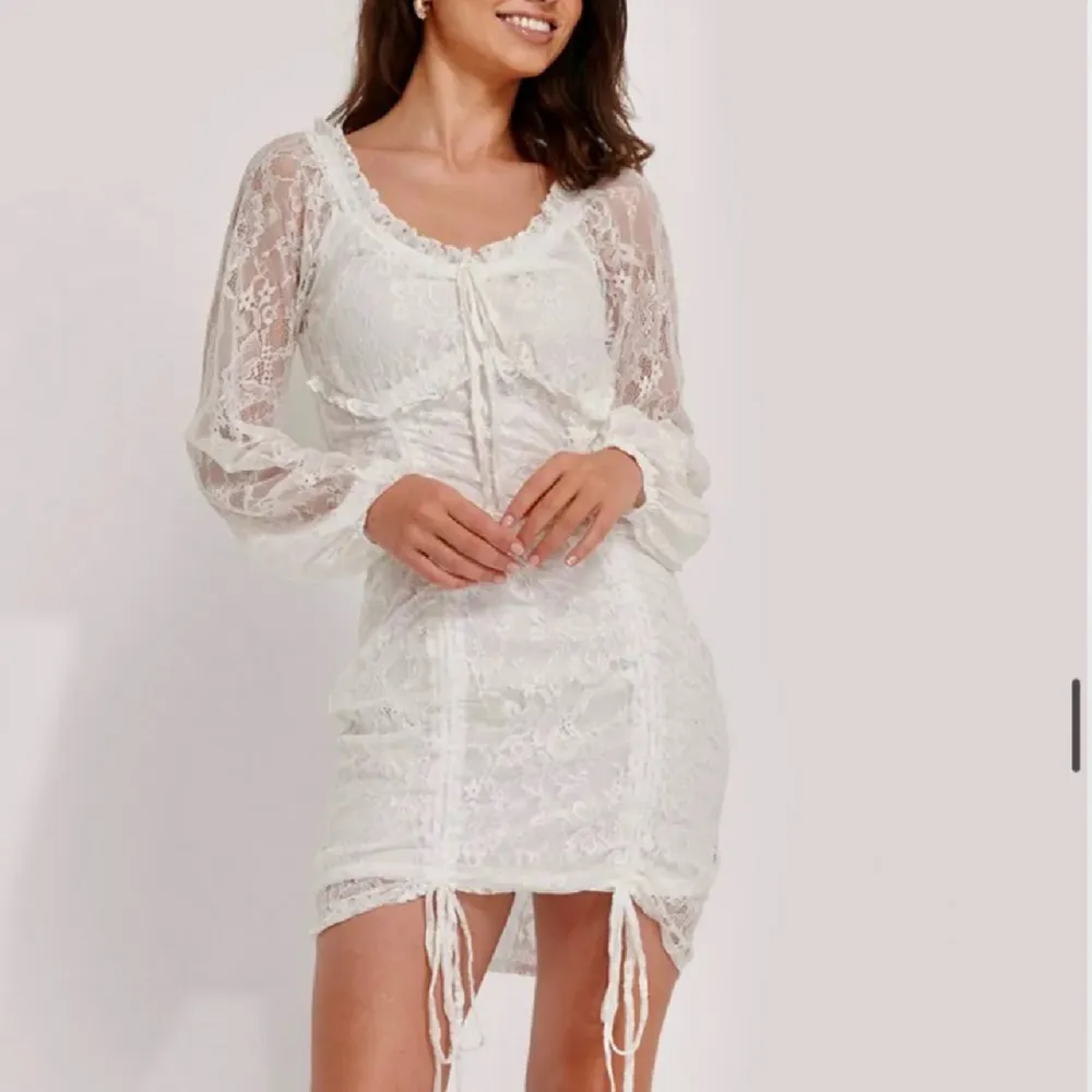 Säljer denna supersnygga vita spets klänningen från NAKD som inte går att få tag på längre. Aldrig använd så helt i nyskick och passar perfekt till studenten💗Går även att ha offshoulder💗 . Klänningar.