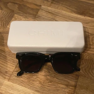 Chimis 04 - Super snygga svarta chimis 04, säljes då de är lite för stora för mig. Tygpåse medföljer ej och fodralet är lite trasigt, därav de billiga priset. Men brillorna är i super fint skick! 🫶Hör av er vid frågor!