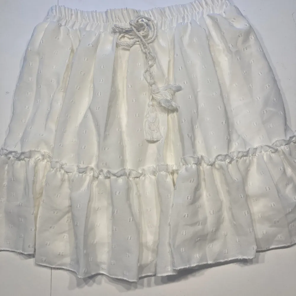 Fin vit kort kjol med insydd underkjol. Resår i midja.  Använd endast 1 gång, nyskick! . Kjolar.