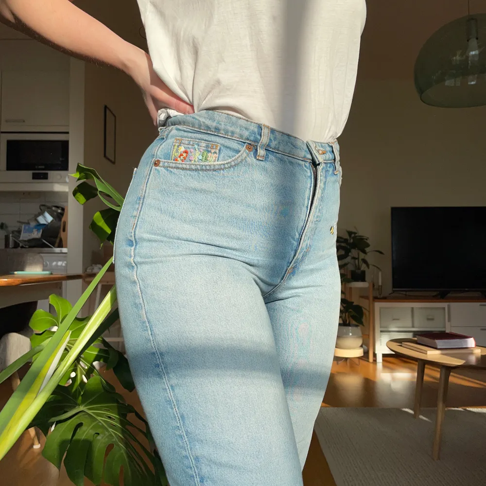 Ljusblå jeans från Monki som jag har broderat på. Högra fickan har en liten blomsteräng och på vänster höft/ljumske finns ett litet bi. Storlek 27, passar en S/XS beroende på hur man vill att passformen ska vara.. Jeans & Byxor.