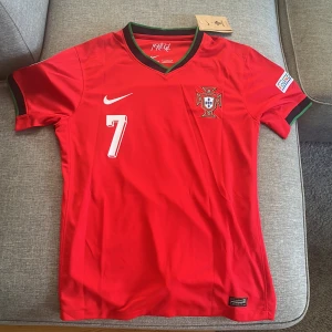 Ronaldo Fotbollströja - Cristiano Ronaldo tröja från EM 2024. Inte äkta, men helt ärligt 11/10 kvalité. Den är i storlek L, men fungerar absolut för M också. Aldrig någonsin haft på mig den. Nypris 650kr. Säljer för 500kr. Kan mötas upp i Stockholm.
